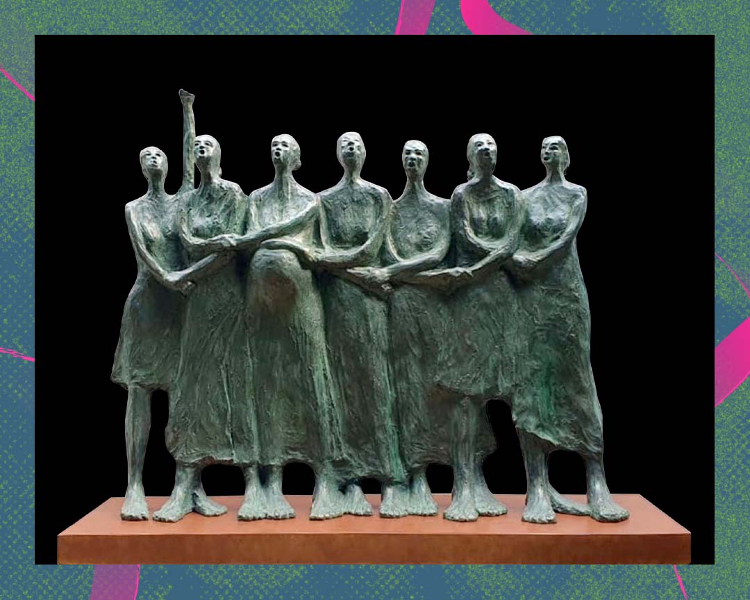 A sculpture of seven female figures with hands interlinked and one raising a clenched fist in the air.
